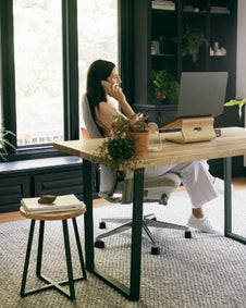 A woman talks on the phone at her Elements desk.
