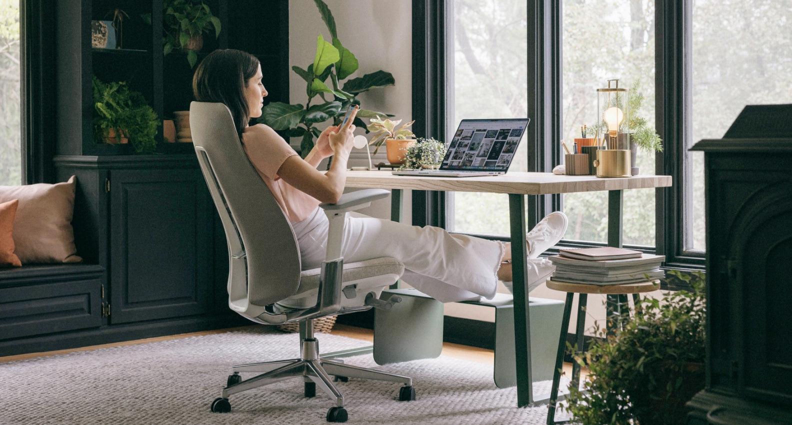A woman sitting in a Haworth Fern chair while working from home.