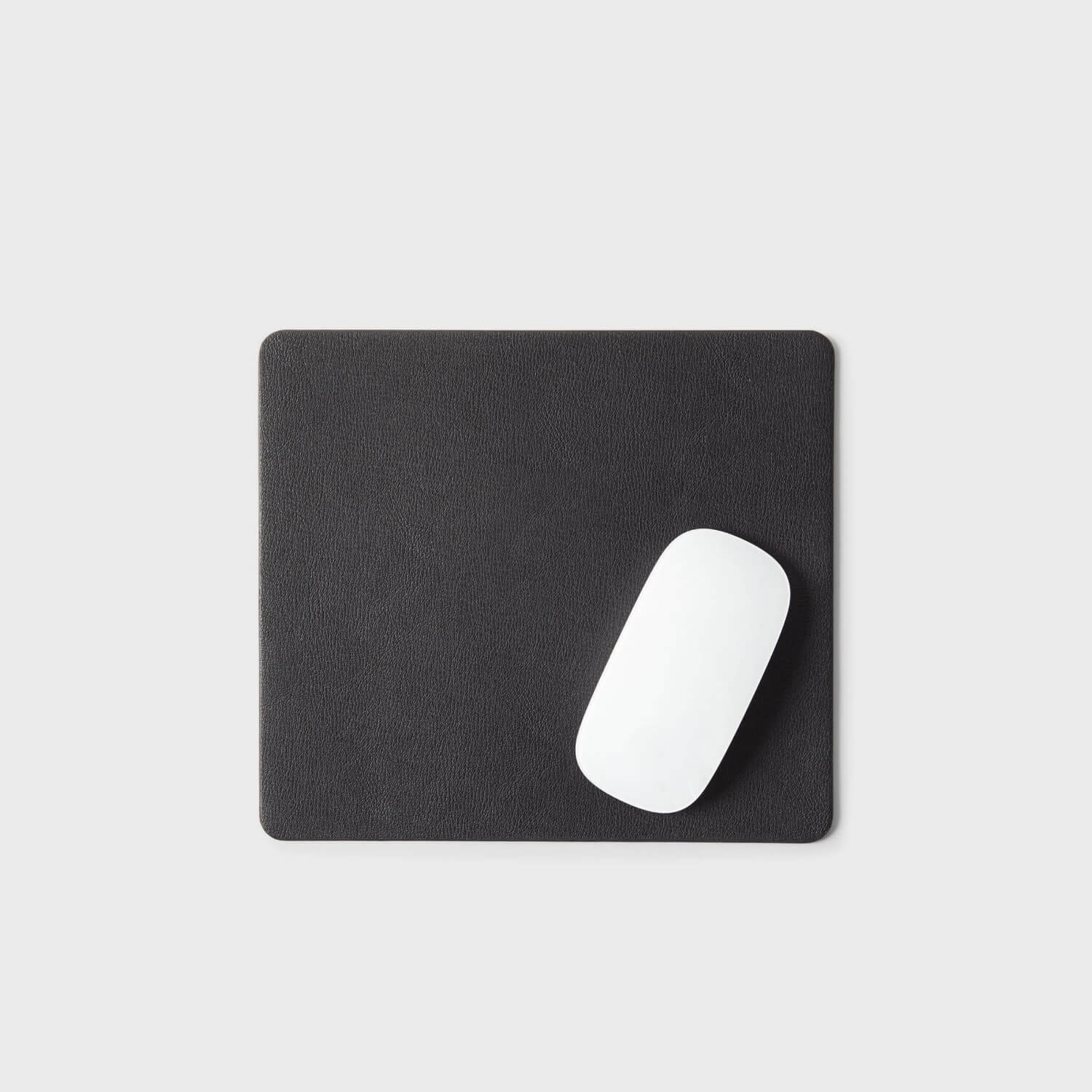 Sleek black leather mouse pad with a white mouse, perfect for stylish and functional workspace setups by Leatherology.