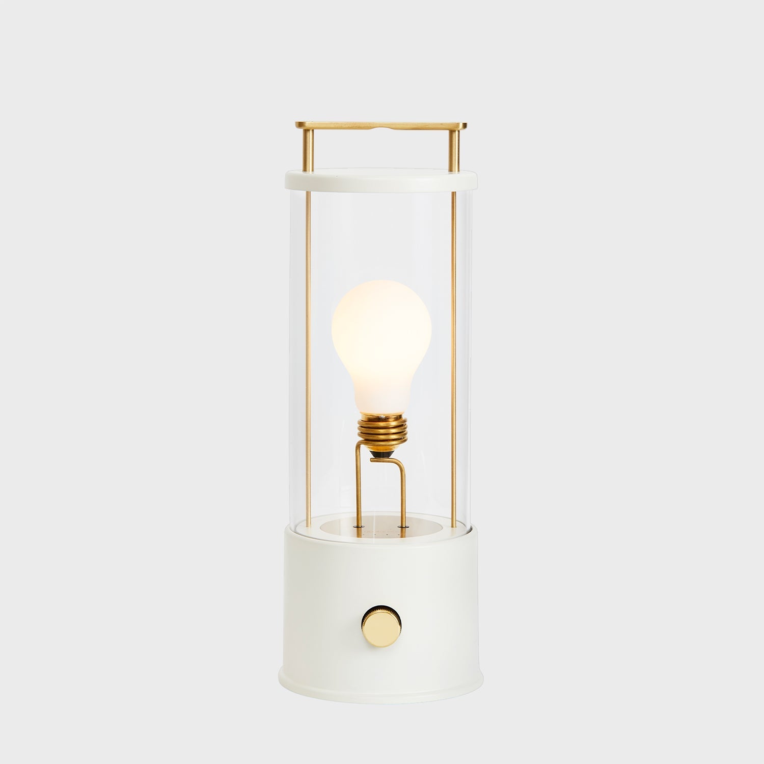 Modern white and gold table lamp with exposed bulb and cylindrical design.