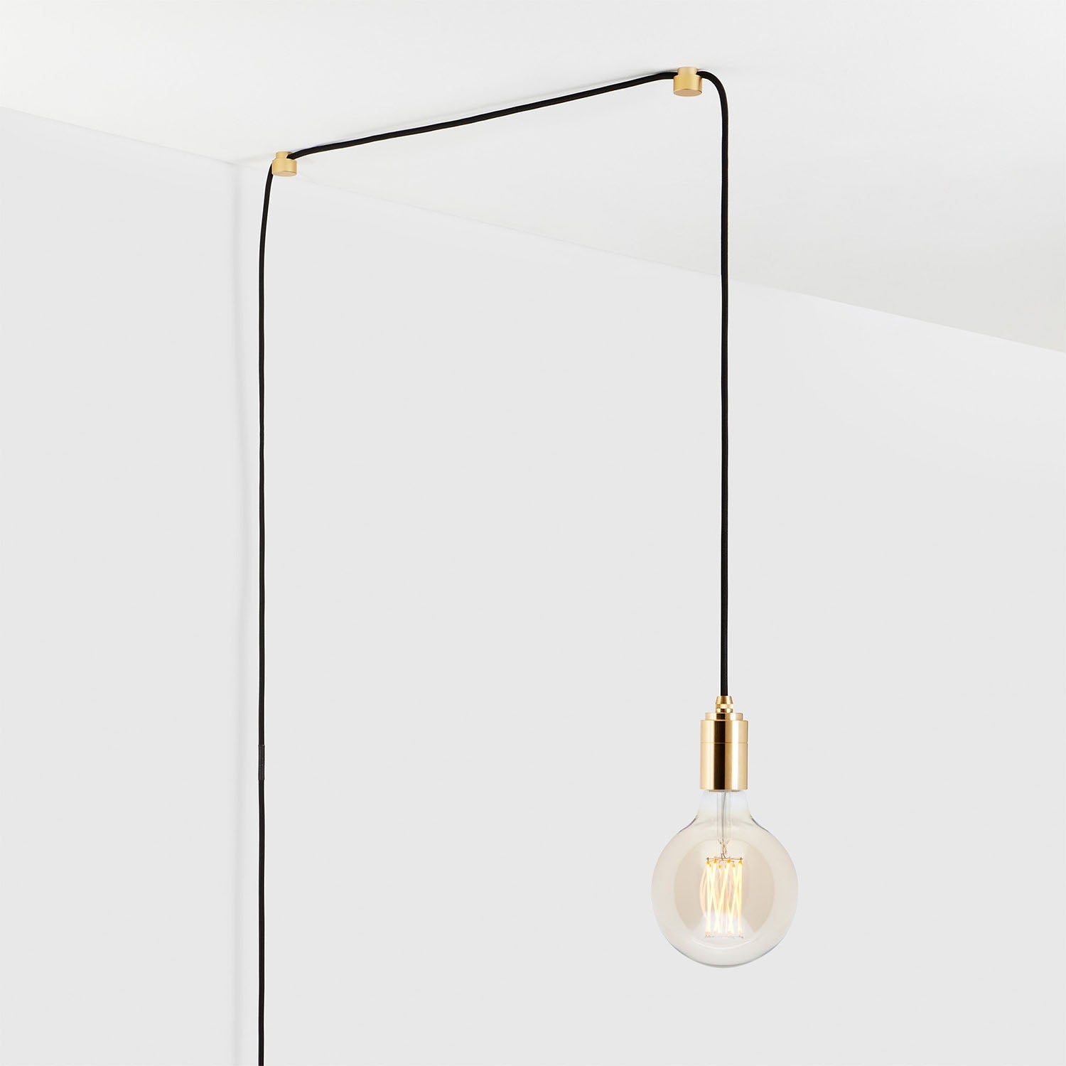 Modern hanging light bulb with black cord and minimalist design against a white background.