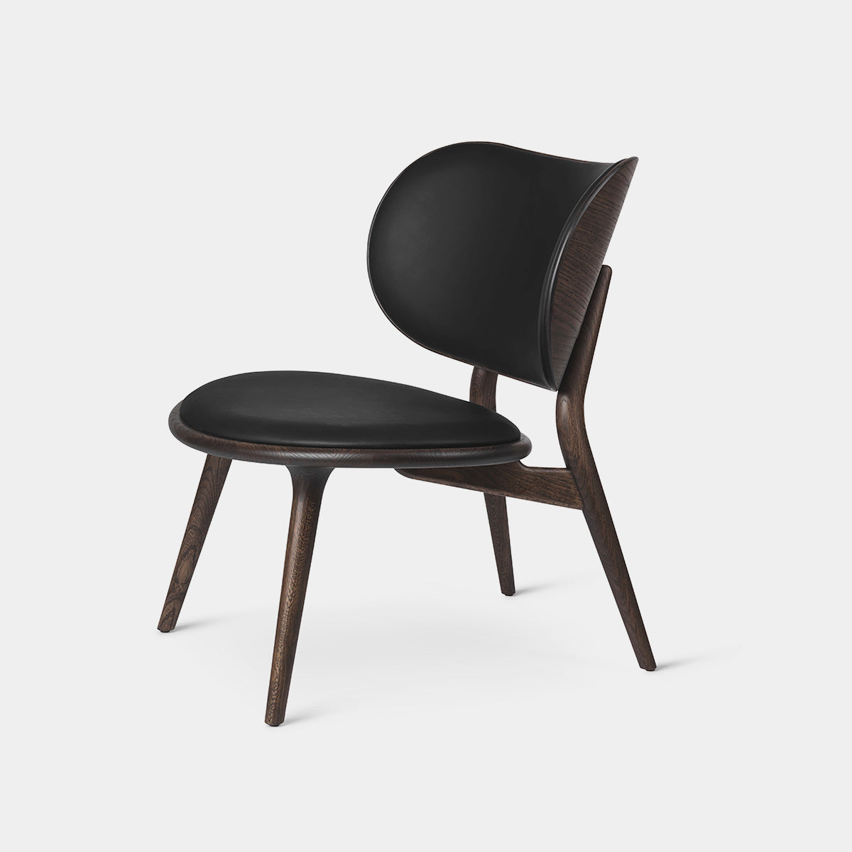 Mater Lounge Chair in black leather with sculptural design and wooden legs, perfect for modern interiors.